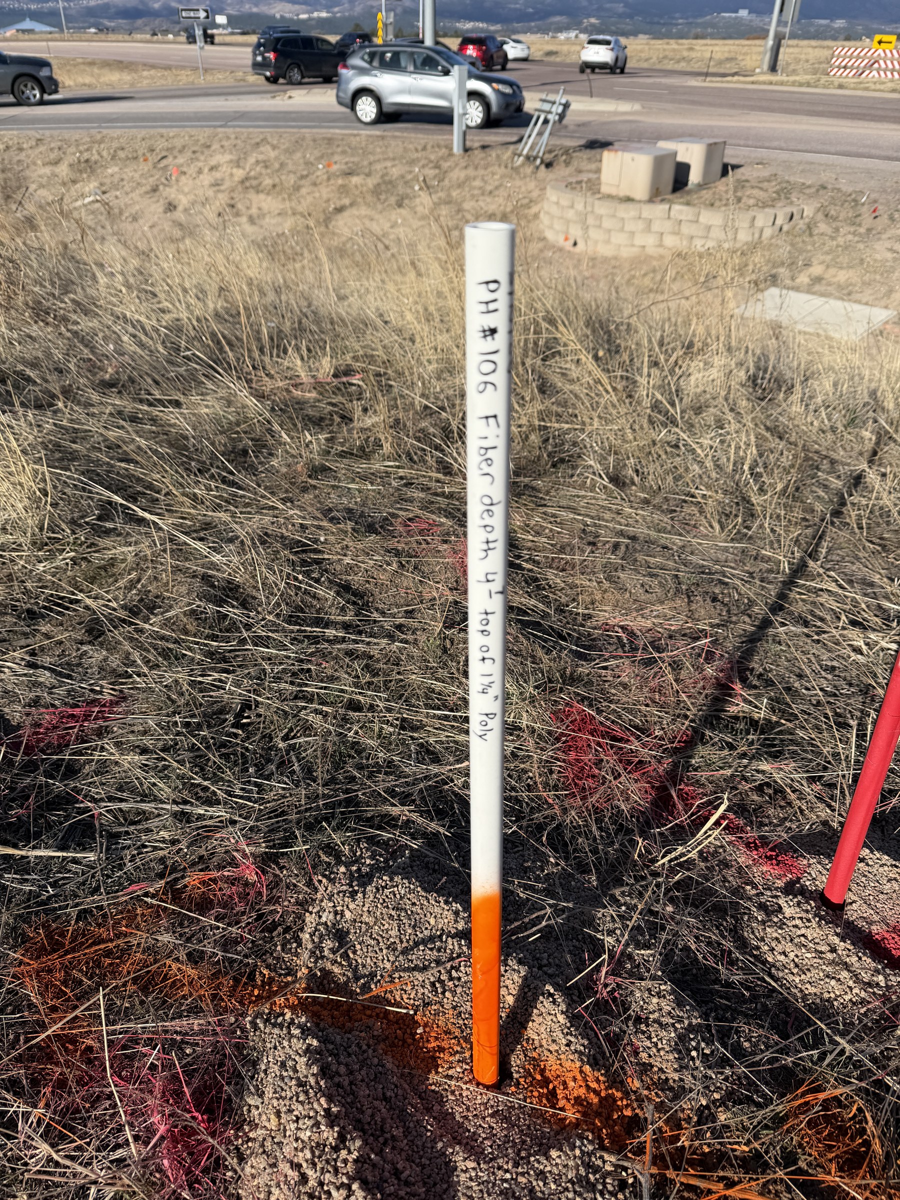 Labeled PVC marking stick noting fiber depth and material