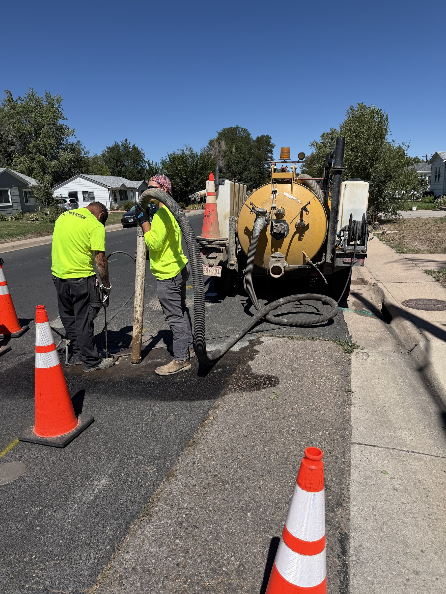 Hydro-excavation crew exposing a utility at an open test hole